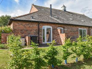 una casa de ladrillo con árboles delante de ella en The Dairy At Brook House Farm-uk40631 en Church Minshull