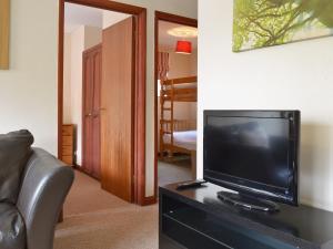 a living room with a flat screen tv on a table at Sycamore Cottage in Cote