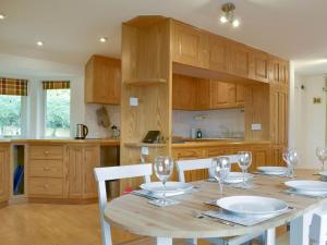 a kitchen with a wooden table with wine glasses at Leyfield Coach House in Kirkby Lonsdale