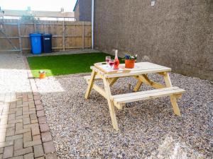 a picnic table and a bench in a backyard at Robins Nest in Broomhill