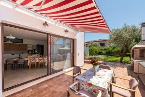 un patio avec une table, des chaises et un parasol dans l'établissement Villa Eleonora Residence App to 4, à Capoterra