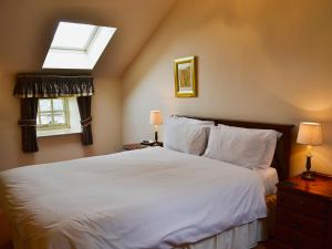 sypialnia z dużym białym łóżkiem i oknem w obiekcie Aubretia Trail-mjb w mieście Akeld