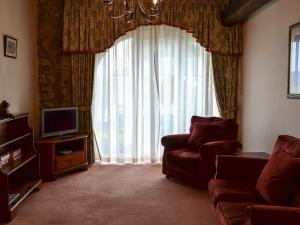 a living room with a couch and a large window at Aubretia Trail-mjb in Akeld