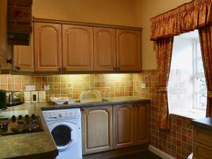 a kitchen with a washing machine and a sink at Aubretia Trail-mjb in Akeld