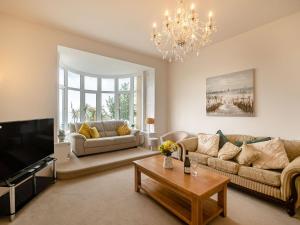 a living room with a couch and a tv at Babbacombe House in Torquay
