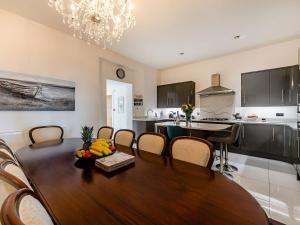 a kitchen and dining room with a wooden table and chairs at Babbacombe House in Torquay