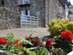 a garden with red flowers in front of a building at Rosedale- Lyl in Ireby