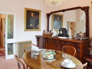 ein Esszimmer mit einem Tisch und einem Spiegel in der Unterkunft The Savoy in Buxton