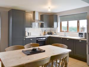 a kitchen with a wooden table and some chairs at Carp Cottage - Ukc1907 in Doddington