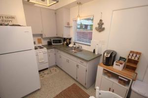 a kitchen with a white refrigerator and a sink at Cute Lil Oasis on Osprey in Sarasota