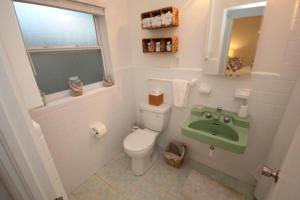 a bathroom with a toilet and a green sink at Cute Lil Oasis on Osprey in Sarasota