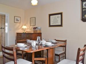 a dining room with a table with chairs and a tableablish at Honeysuckle Cottage in Minsterley