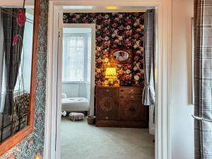 a bathroom with a wall covered in flowers at Toll House in Berwick-Upon-Tweed