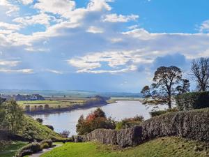 a view of a river from a hill with a stone wall at Toll House in Berwick-Upon-Tweed