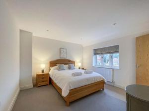 a bedroom with a large bed and a window at Lavender Cottage in Stelling