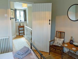 a room with a bed and a table and a chair at Squirrel Cottage in Hook Norton