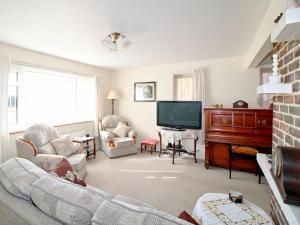 a living room with a couch and a television at Kingsway Court in Seaford