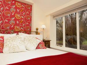 a bedroom with a bed and a large window at Gamekeepers Cottage in Staple