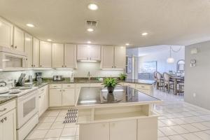 a large kitchen with white cabinets and a table at The Palms #1002 in Orange Beach