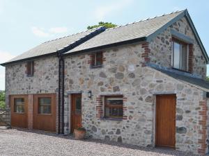 a stone house with wooden doors and windows at Bryn Menai - Hw7573 in Llanddeiniolen