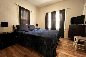 a bedroom with a bed and a flat screen tv at Historic 1920 Bungalow Minutes from DTSP in St Petersburg