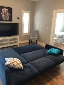 a large blue couch in a living room with a television at Historic 1920 Bungalow Minutes from DTSP in St Petersburg