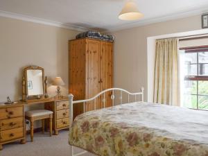 a bedroom with a bed and a dresser and a mirror at Low Cordorcan - Uk5891 in Bargrennan