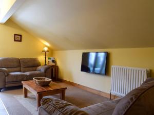 een woonkamer met 2 banken en een flatscreen-tv bij Mange-tout Maison - Uk32607 in Manton