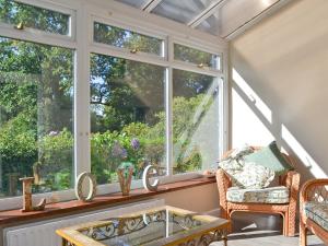 um jardim de Inverno com janelas, uma mesa e cadeiras em Corner Cottage - Lp2 em Windermere