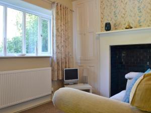 un soggiorno con TV e camino di Corner Cottage - Lp2 a Windermere
