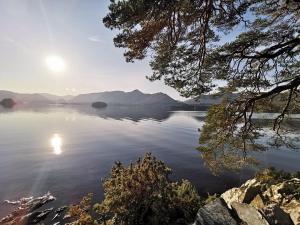 uma vista de um grande corpo de água com o sol no céu em Limetrees em Keswick