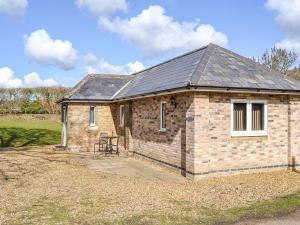 a small brick house with a table in front of it at The Pump House in Cawston