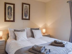 a bedroom with a white bed with towels on it at Beck Foot Cottage in Sedbergh