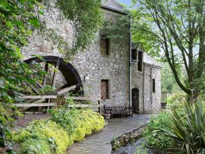 an old stone building with a bench in front of it at The Hayloft in Milnathort