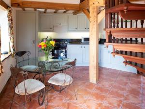 a kitchen with a glass table and some chairs at The Hayloft in Milnathort