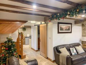 una sala de estar con un árbol de Navidad y un sofá en Tawny Owl Barn, en Barlow
