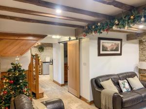 a living room with a christmas tree and a couch at Tawny Owl Barn in Barlow