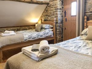 1 dormitorio con 2 camas y toallas. en Tawny Owl Barn, en Barlow