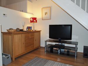 a living room with a tv on a dresser and a staircase at The Bishops Court in York