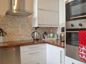 a kitchen with white cabinets and stainless steel appliances at The Bishops Court in York