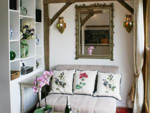 a living room with a couch and a mirror at The Cart Shed in Ibstone