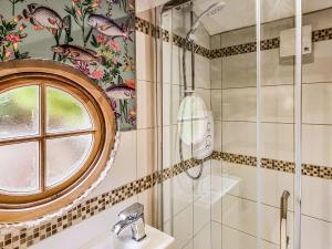 baño con ducha, lavabo y ventana en Walnut Lodge en Wells