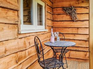 Walnut Lodge في ويلْزْ: طاولة وكراسي على شرفة كابينة