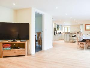 a living room with a flat screen tv on a wooden entertainment center at North Barn in Monk Okehampton