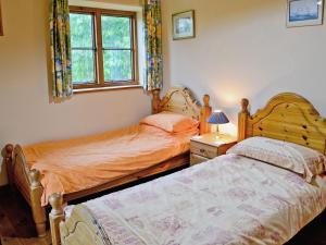 a bedroom with two beds and a window at Blackberie Cottage - E2389 in Stoke Abbott