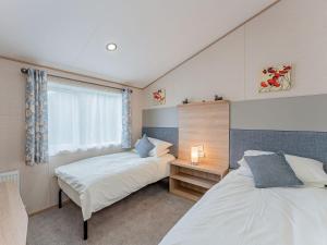 a bedroom with two beds and a window at Cledan in Llanon