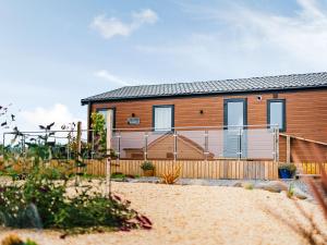 a house on the beach with a fence at Cledan in Llanon