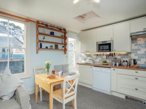a kitchen with white cabinets and a wooden table and a tableablish at Dartview in Dartmouth