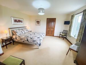 a bedroom with a large bed and a window at Friarystone Cottage in Bamburgh