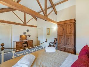 a bedroom with a bed and a wooden cabinet at The Grainery - Uk37516 in Routh